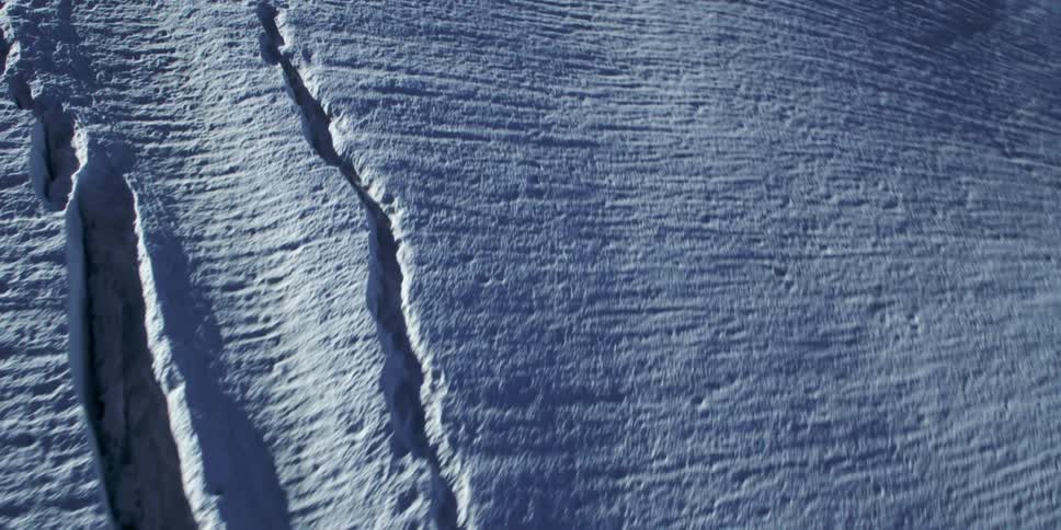 The slope has track marks in the snow