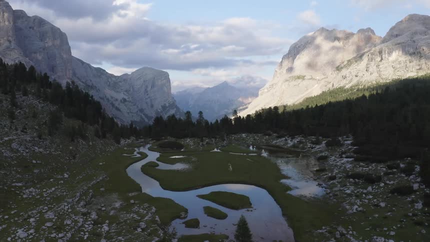 A marsh in the valley between mountain ridge during the day
