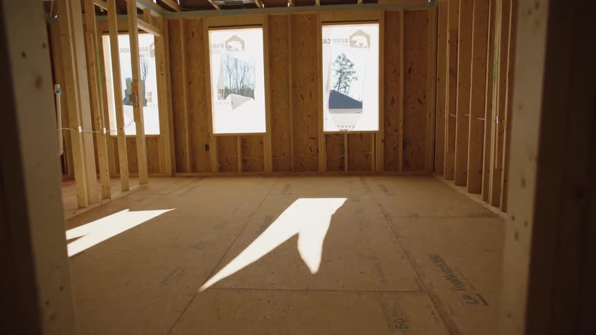 Sun shines through frosted glass in doors into unfinished wooden room