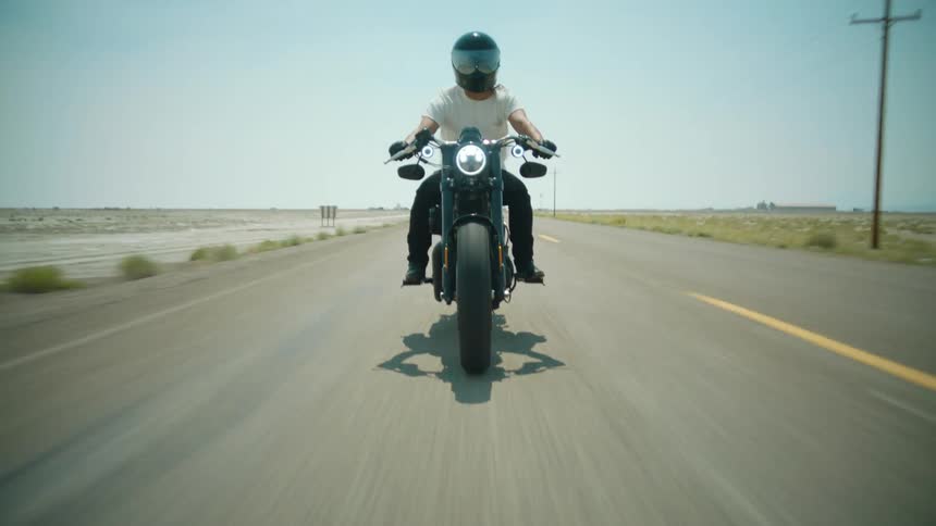 A man driving a motorcycle down a road