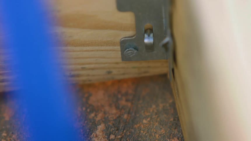 A hammer pounding a nail into a piece of wood