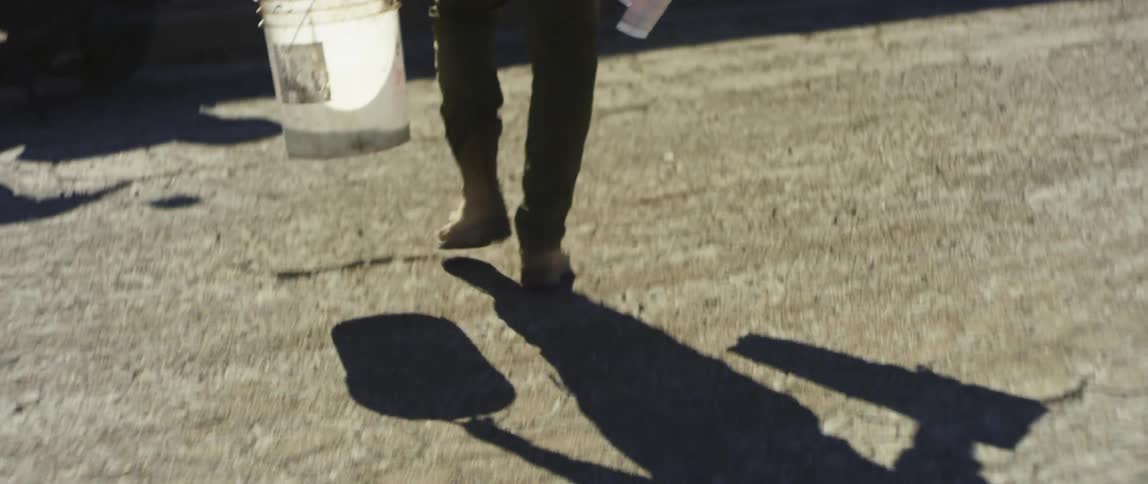 A man walking with a bucket
