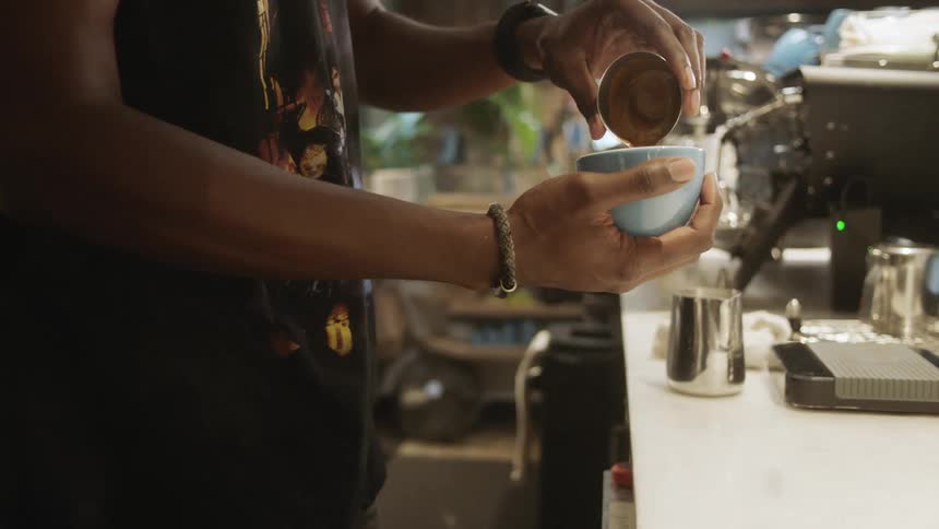 A man is preparing a beverage in the cafe