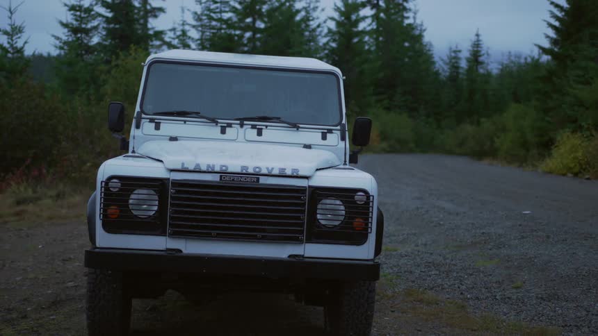 A white sport utility vehicle is parked on a dead end road