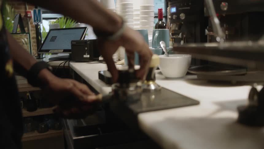 A man is loading coffee into a machine