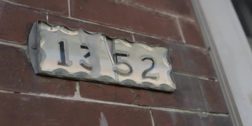 A sign on a building has numbers on it