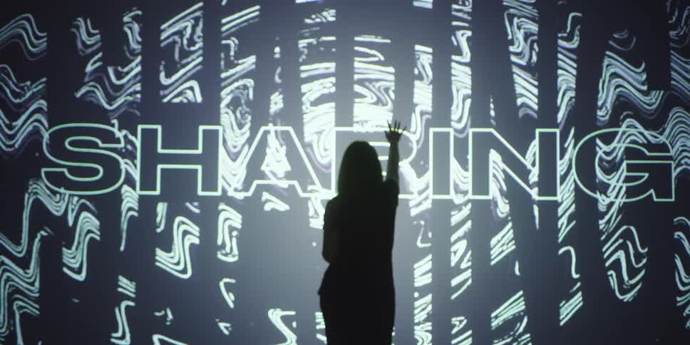 A woman touches the words on the large display
