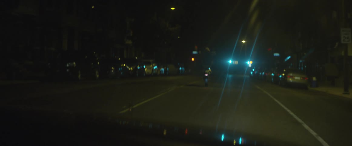 Vehicles are driving down a street at night