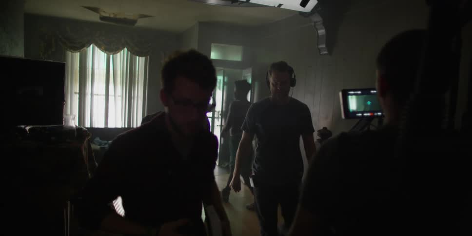 A film crew is working in a dark room