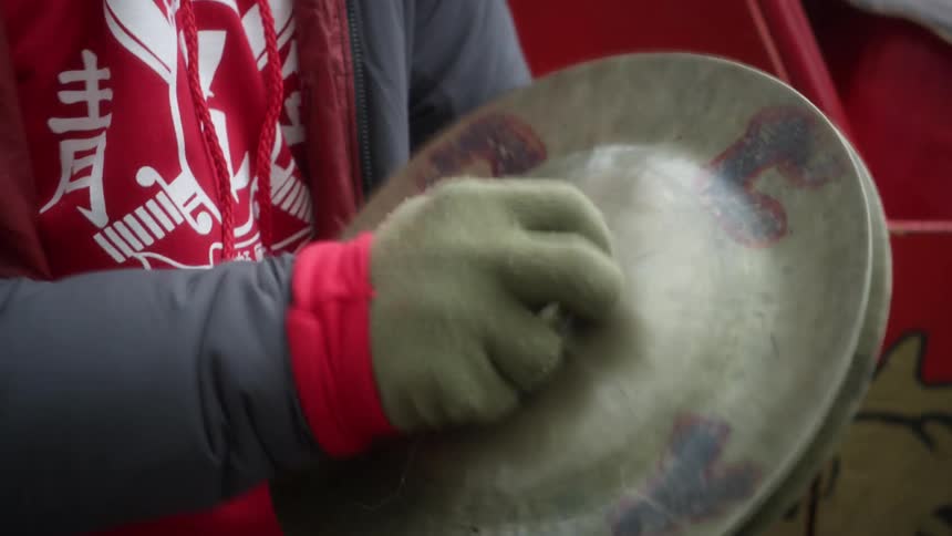 A person is tapping some cymbals together