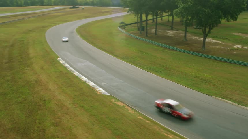 An aerial view of cars driving around on a track