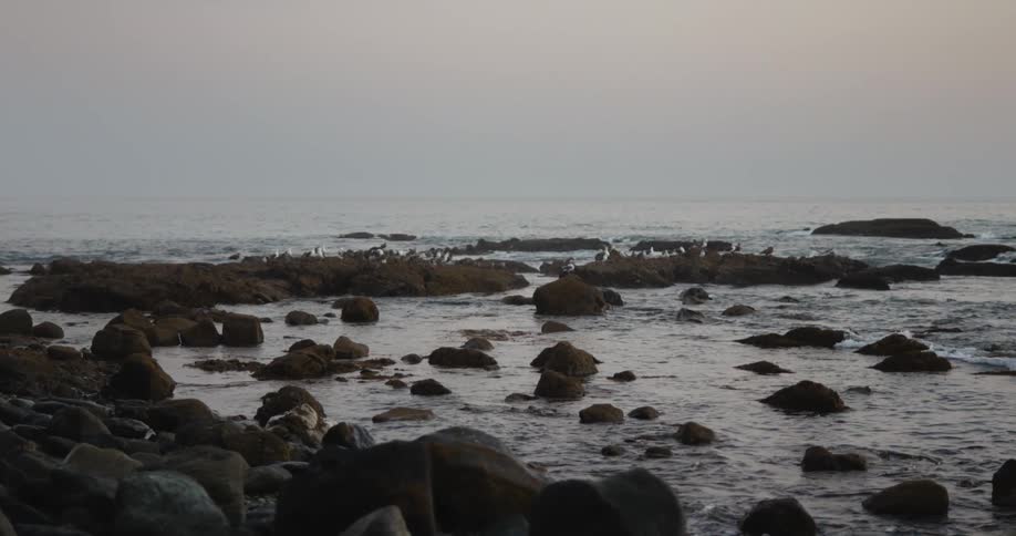 A view of waves crashing against rocks outdoors