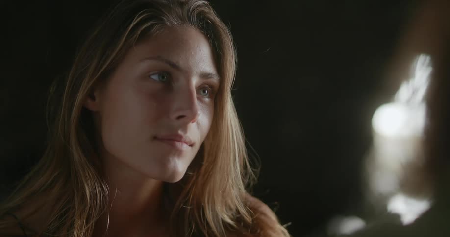 Woman with brown hair looks at man in cave