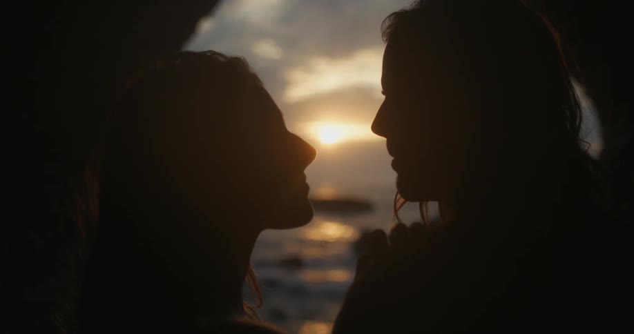 Two people holding each other close at sunset