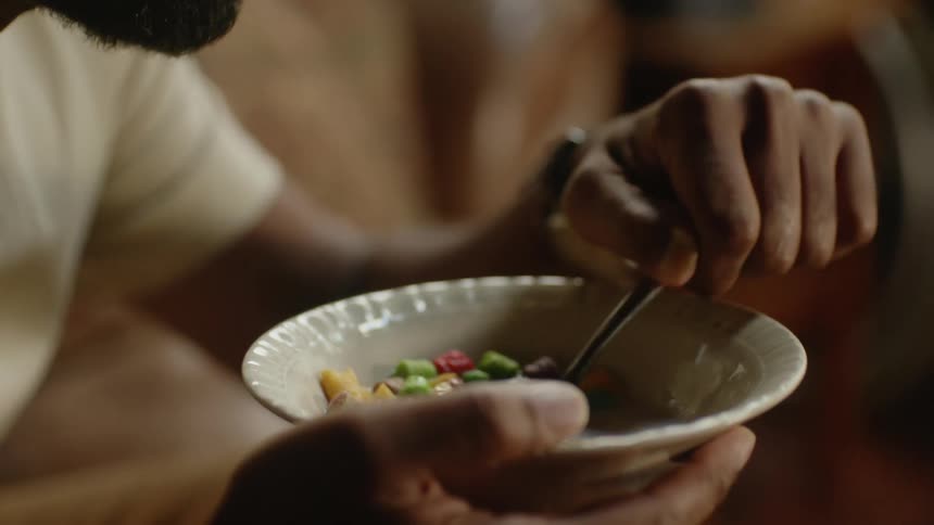 A man is eating a bowl of cereal