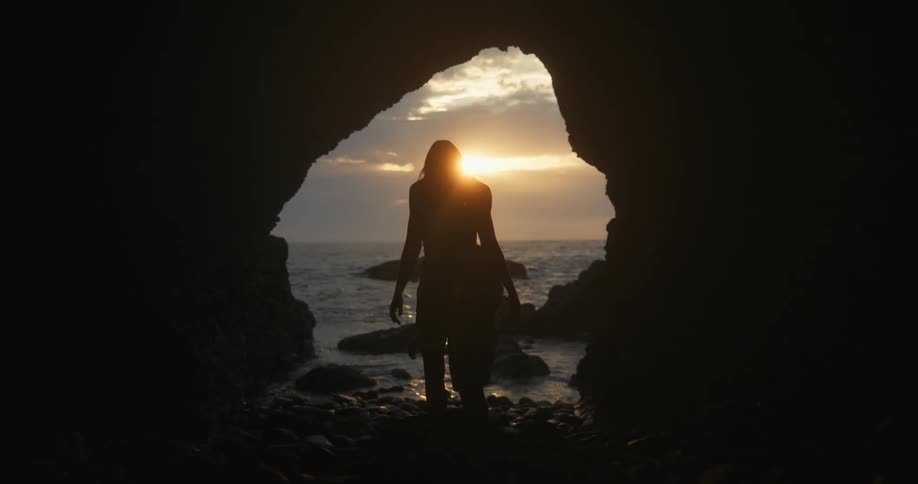 Two people exit the dark cave