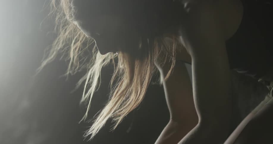 Woman bending down as the breeze blows her hair