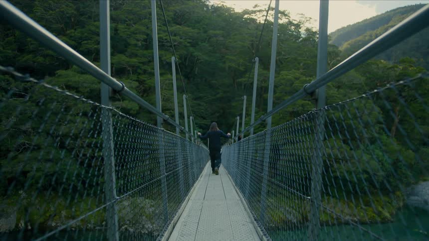 A man hiking across a bridge