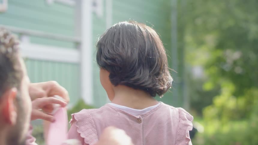 A child nodding and getting a backpack put on them