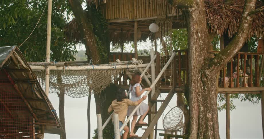 A man and woman walk up stairs to a seating area on the shore
