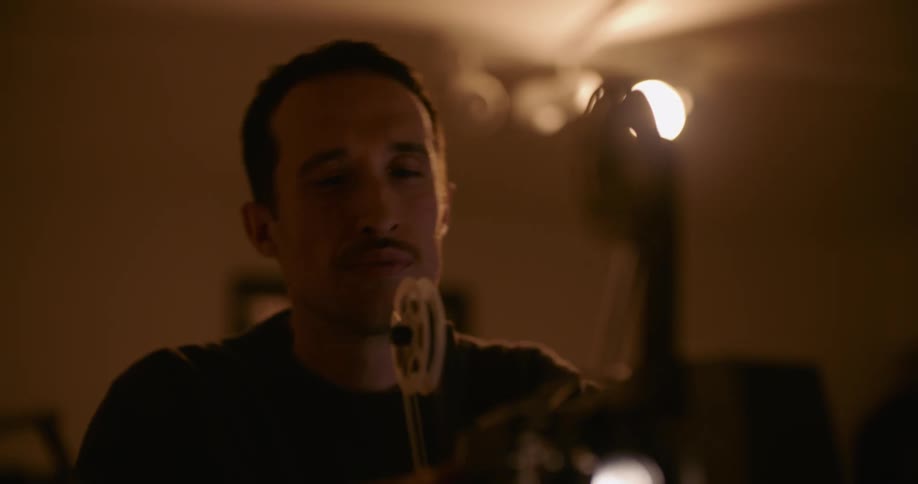 A man working a projector in a room