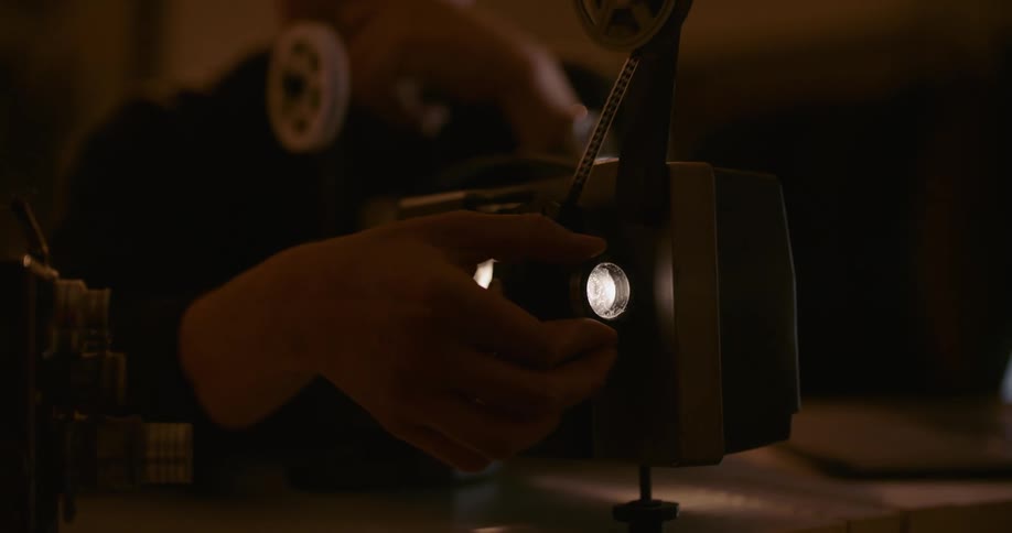 A man smiles while watching video using a projector