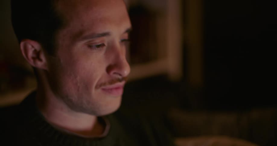 A man is nodding while watching something
