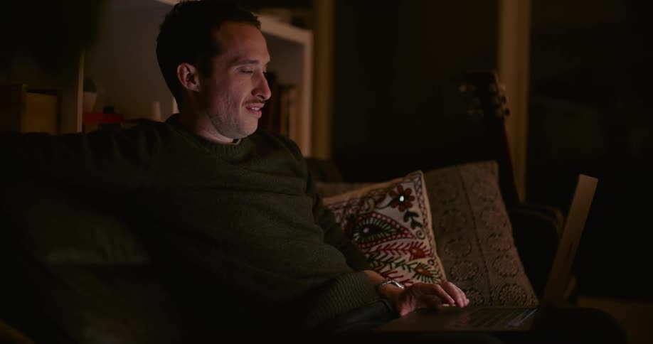A man working on a laptop while sitting on a couch