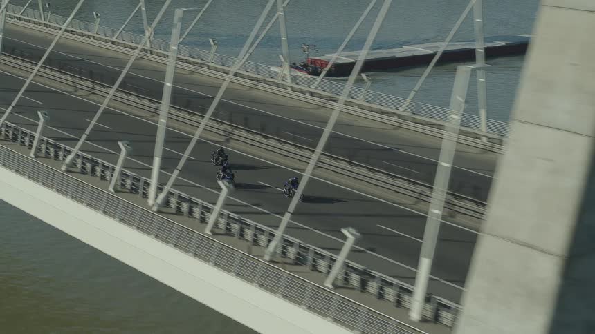 Motorbikes driving across a bridge