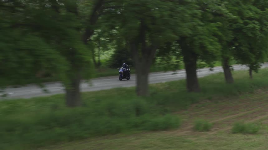 A person riding a motorcycle down a road
