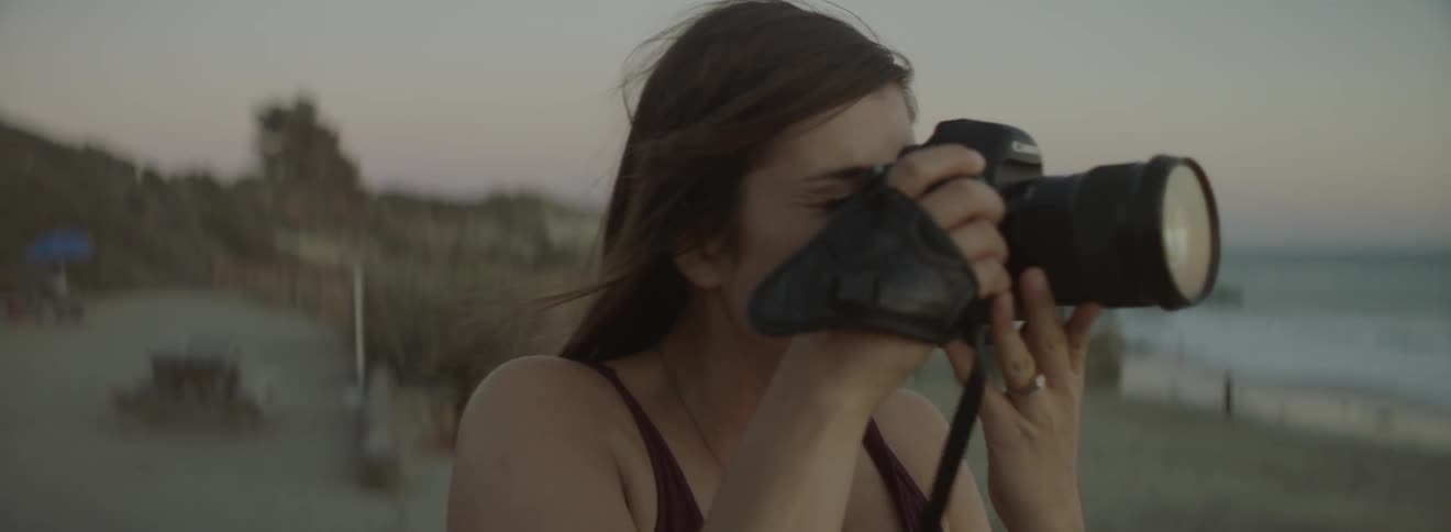 A women takes photographs on the beach
