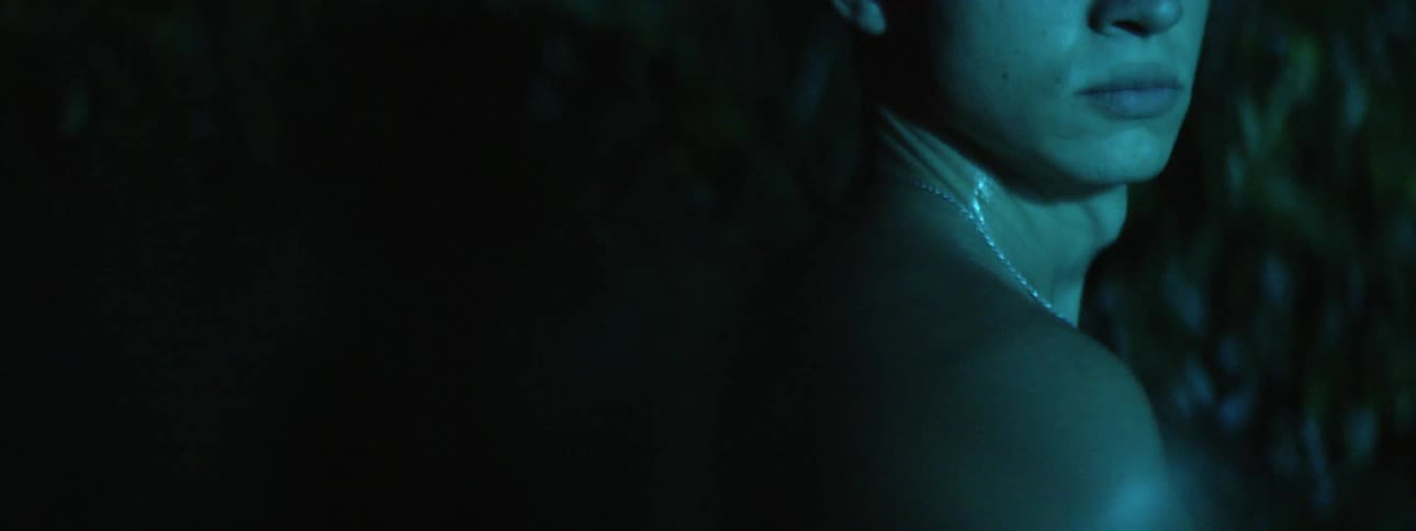 A man turning towards the camera at night outdoors