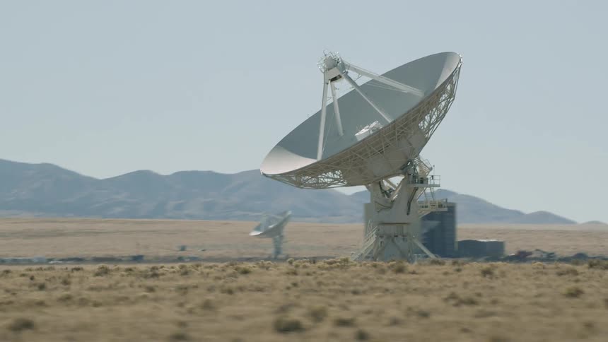 Large satellite dishes line the desert