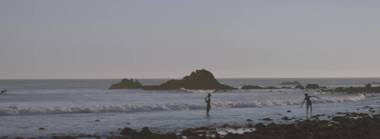 People throw rocks into the ocean on a clear day
