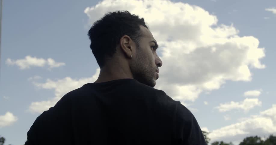 A man is walking outside on a cloudy day