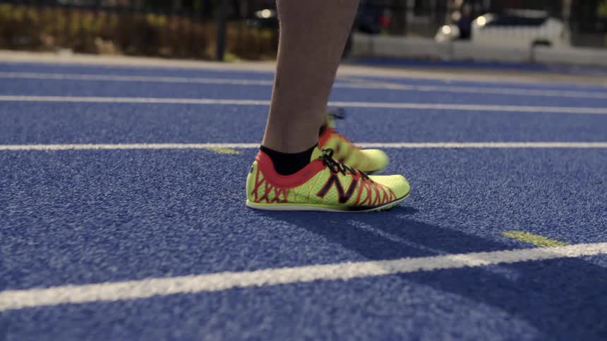 A person is walking on a blue track