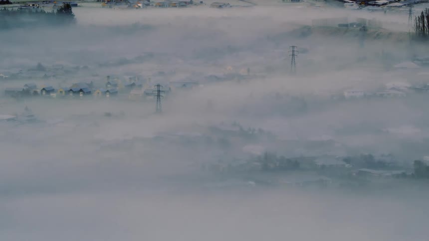 A view of a city under clouds and fog
