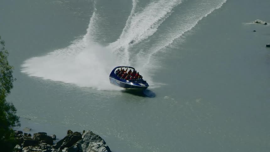 Happy passengers of a recreational boat speeding over the a river