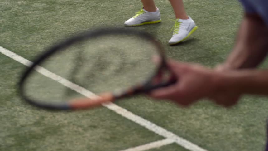 Man spins tennis racket on his hands before a match