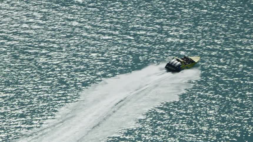 The boat is traveling in the water on a sunny day