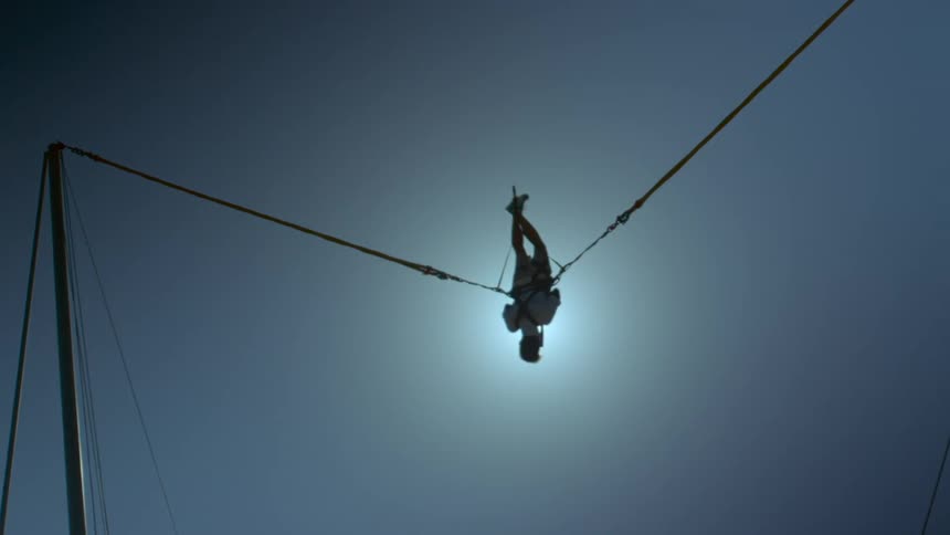 Acrobat spins around on a highwire
