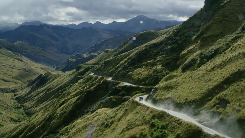 A vehicle is driving around the mountain