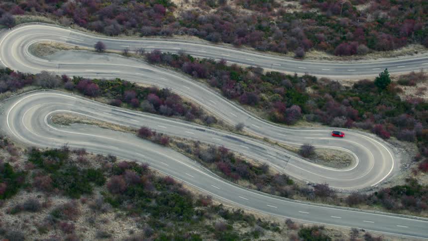 A car driving on a twisty road over flat terrain