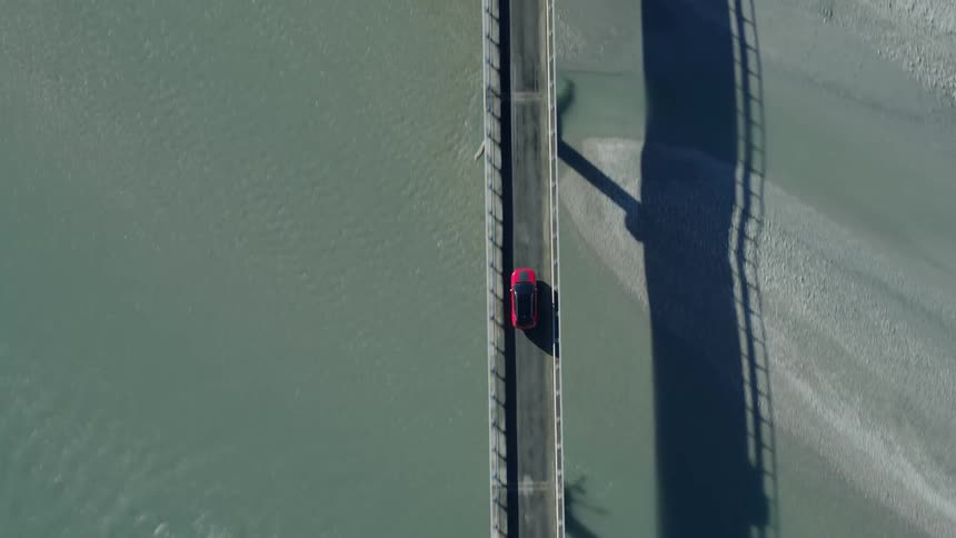 A vehicle driving on a bridge over a river