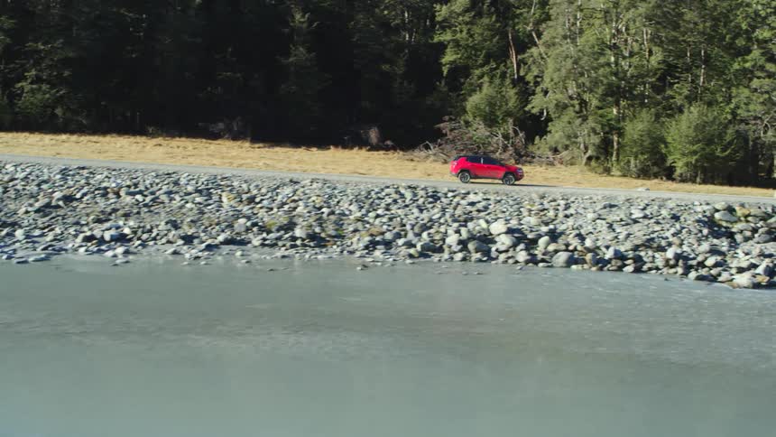 A vehicle is driving off road by the stream