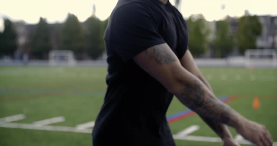 A man walks forward stretching his arms out to the side