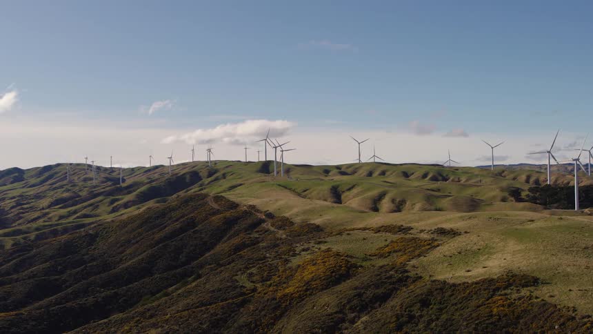 Wind turbines on green hills on a sunny day