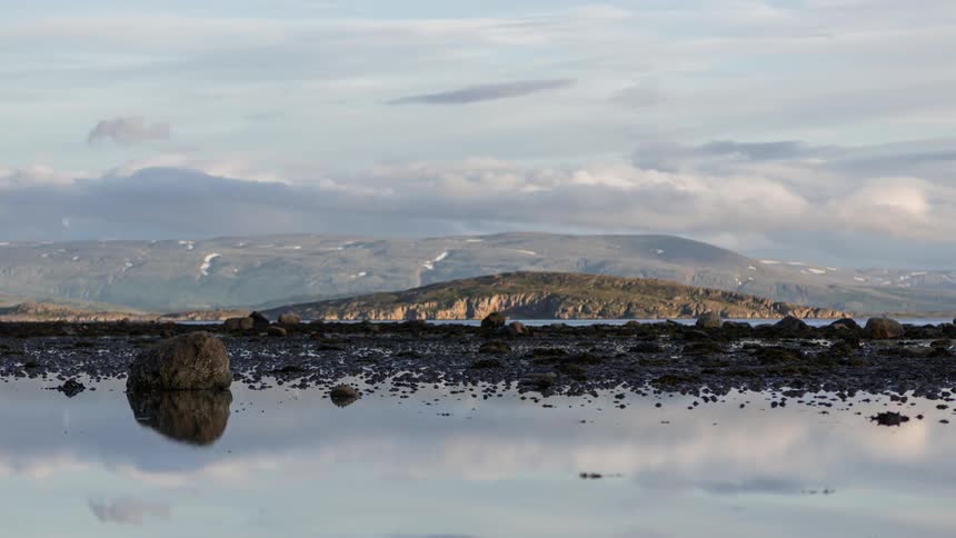 Clouds rolling over mountains at low tide