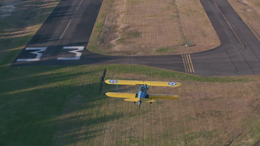 A small plane flies over an airfield