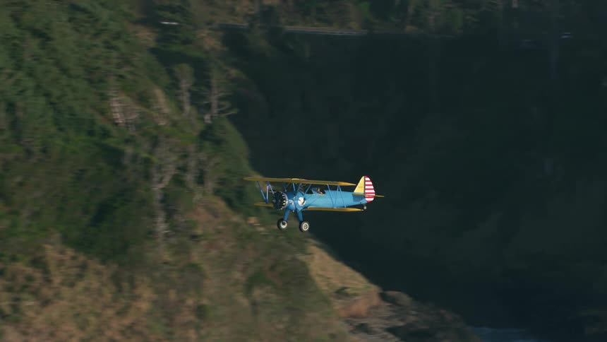 Blue and yellow biplane lands in the field